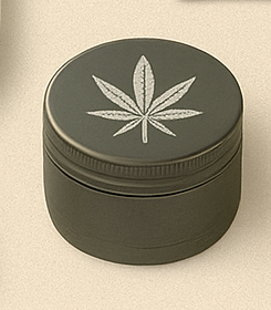 The Ouid Store matte olive metal grinder with engraved leaf design